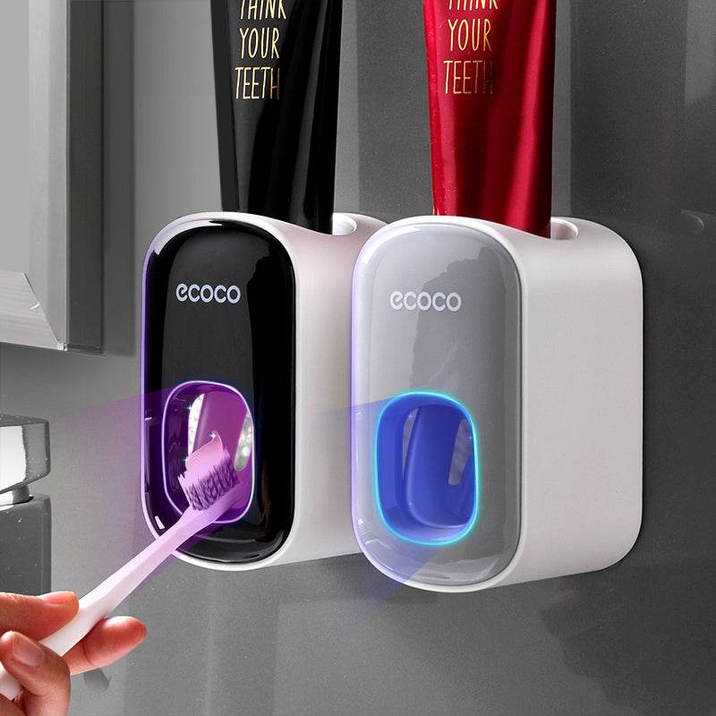 Wall mounted automatic toothpaste holder dispensing toothpaste onto toothbrush in modern bathroom